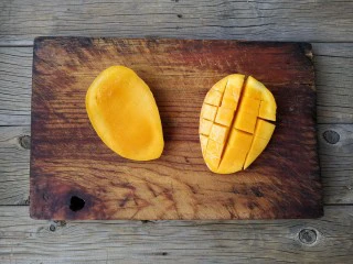 芒果黑糯米甜甜——夏日里的清凉甜意,芒果对剖切成两片，将其中一片切成格子，剔下果肉。