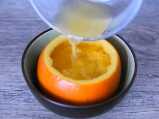 最好的止咳方法——盐蒸橙子,将果肉放入橙皮中，倒入橙汁