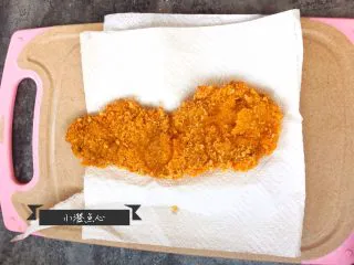 超级酥脆的炸猪排,猪排放在厨房用纸上，用厨房用纸吸出猪排表面多余的油分。 