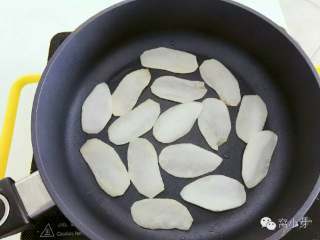 宝宝辅食：芋头脆片,平底锅，烧热，刷一层植物油，转小火，把切好的芋头片平铺放入锅中。 》不需要太多油的，建议用平底不粘锅。 》也可以用烤箱，温度和时间见最后面tips。