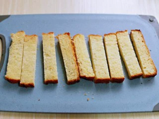 简单快手小零食～黑芝麻椰香吐司条,首先将吐司切成条。(我的吐司提前做的，买来的也可以哈)