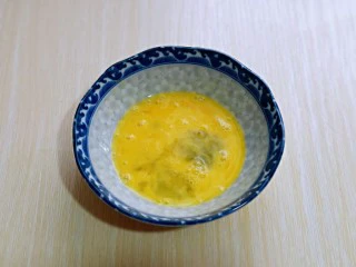 简单快手小零食～黑芝麻椰香吐司条,鸡蛋打入碗中，用筷子打散。