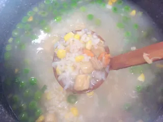 冬日暖心菜 扇贝田园砂锅粥,再加入腌制好的扇贝肉，搅拌均匀。