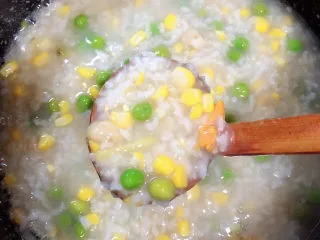 冬日暖心菜 扇贝田园砂锅粥,盖盖儿继续小火炖，时不时搅拌一下，避免糊底。扇贝肉小火儿熬制5-8分钟即可。