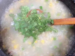 冬日暖心菜 扇贝田园砂锅粥,出锅前撒上香菜末。